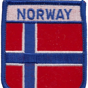 May include: A red, white, and blue embroidered patch with the word "NORWAY" in white lettering on a white background. The patch is shaped like a shield.