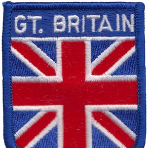 Pode incluir: Um remendo bordado azul com o texto "GT. BRITAIN" e uma bandeira do Reino Unido vermelha, branca e azul.