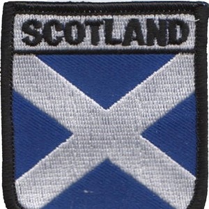 May include: A blue and white embroidered patch with the word "SCOTLAND" in black lettering. The patch features a white cross on a blue background.
