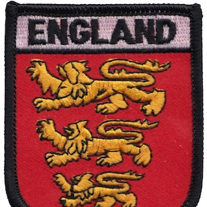 Puede incluir: Parche bordado con la palabra "ENGLAND" en la parte superior. El parche presenta un escudo rojo con tres leones dorados. El parche tiene un borde negro y un fondo blanco para la palabra "ENGLAND".