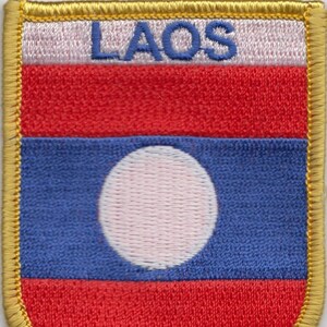 May include: A red, white, and blue embroidered patch with the word "LAOS" in blue lettering. The patch has a white circle in the center of a blue field.