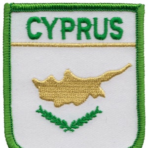 May include: Green embroidered patch with the word "CYPRUS" in green letters, a gold outline of the island of Cyprus, and a green laurel wreath.