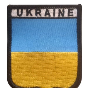 Puede incluir: Parche bordado con la bandera ucraniana. El parche tiene un diseño azul y amarillo, con la palabra "UKRAINE" en letras blancas en la parte superior. El parche tiene un borde negro.