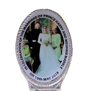 Può includere: Un cucchiaio d'argento con un ciondolo ovale che presenta una foto del principe Harry e Meghan Markle nel giorno del loro matrimonio. Il ciondolo è inciso con il testo "In celebration of the marriage of Prince Harry and Meghan Markle on 19th May 2018."