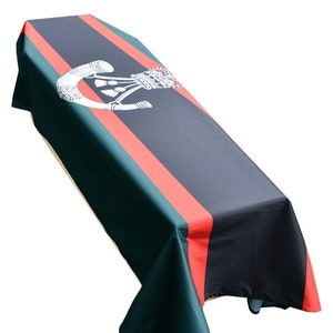May include: A black and green coffin cover with a red stripe and a white emblem of a bugle and crown.
