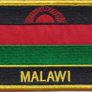 Op de afbeelding: Een geborduurde patch in zwart, rood en groen met een gele rand. De patch heeft een rode opkomende zon met zwarte stralen en het woord "MALAWI" in gele letters.