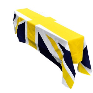 May include: A yellow and navy blue tablecloth with a Union Jack pattern. The tablecloth is draped over a table and has a yellow stripe down the center.