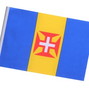 May include: A rectangular flag with a blue background and a vertical yellow stripe in the center. The yellow stripe features a red cross with white accents. The flag is mounted on a white stick.