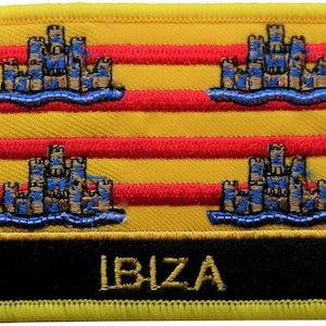 May include: A yellow embroidered patch with red stripes and four brown castles with blue water. The text "IBIZA" is written in gold on a black background at the bottom of the patch.