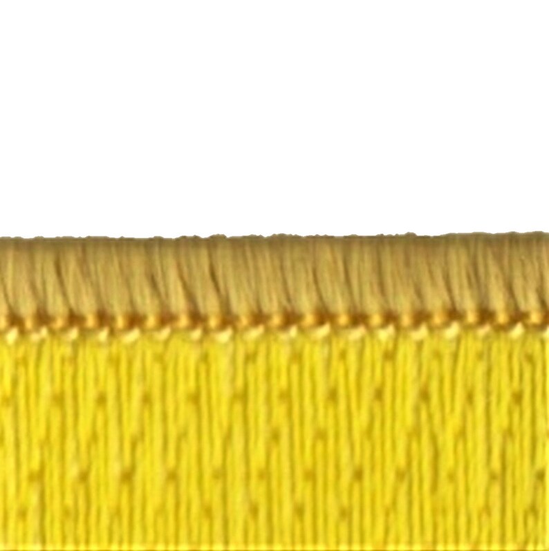 K&ouml;nnte beinhalten: Nahaufnahme von gelbem Stoffbesatz mit Fransenkante. Der Besatz hat eine subtile Textur und einen goldenen Faden, der durch ihn verl&auml;uft.