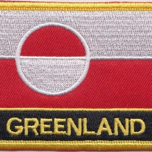 May include: A red, white, and black embroidered patch with the word "GREENLAND" in yellow lettering. The patch features the flag of Greenland, which is a white disc with a red half-circle on a red background.