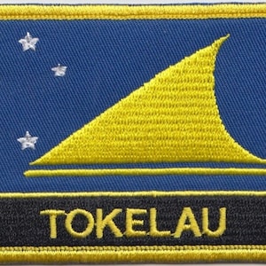 Puede incluir: Un parche bordado azul y amarillo con la palabra "TOKELAU" en letras amarillas. El parche presenta un velero amarillo con una estrella blanca en la esquina superior izquierda.
