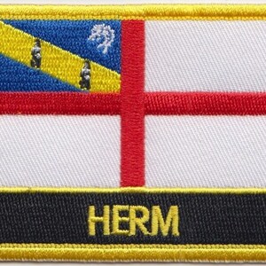 May include: A yellow, red, blue, and white embroidered patch with the word "HERM" in black lettering on a black background.