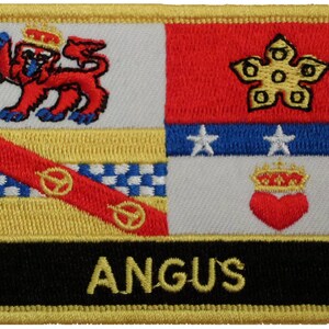 Op de afbeelding: Een geborduurde patch met een gouden rand en een zwarte achtergrond. De patch toont een kleurrijk wapenschild met een leeuw, een ster en een hart. De tekst "ANGUS" staat in gouden letters onder het wapenschild.