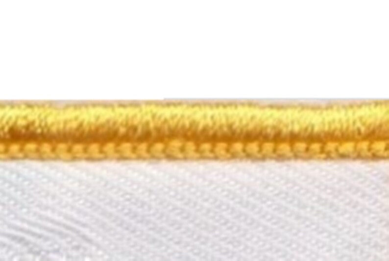 May include: A close-up of a white fabric with a yellow stitched border.