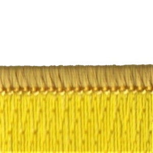 Pu&ograve; includere: Primo piano di un bordino in tessuto giallo con un bordo a frangia. Il bordino ha una texture sottile e un filo dorato che lo attraversa.