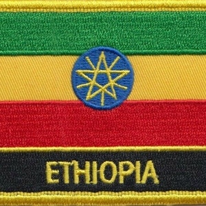 May include: An embroidered patch featuring the Ethiopian flag. The flag is green, yellow, red and black with a blue star in the centre. The text "ETHIOPIA" is written in yellow on the black band.