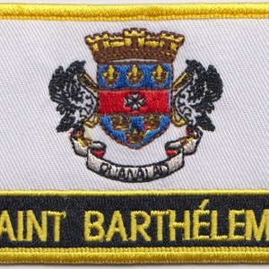 May include: A yellow and black embroidered patch with the text "SAINT BARTHÉLEMY" and a coat of arms featuring a shield with a red, white, and blue design.