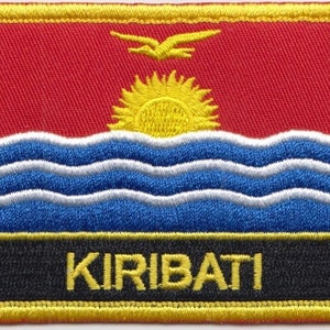 May include: Embroidered patch featuring the flag of Kiribati. The flag is red with a yellow sun and three white wavy lines on a blue background. The word "KIRIBATI" is written in yellow letters on a black background.
