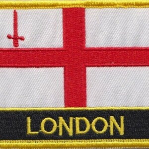 May include: A yellow, black and white embroidered patch with the text "LONDON" and a red cross with a sword on a white background.