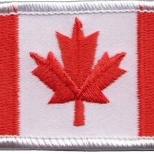 Op de afbeelding: Een rood en wit Canadees vlaggenpatch met een rood esdoornblad in het midden. De patch is geborduurd en heeft een witte rand.
