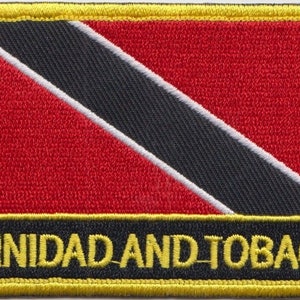 Könnte beinhalten: Gestickter Aufnäher mit der Flagge von Trinidad und Tobago. Das Design zeigt einen roten Hintergrund, einen schwarzen diagonalen Streifen mit weißen Rändern und den gelben Schriftzug "TRINIDAD AND TOBAGO".