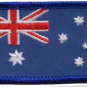 Op de afbeelding: Een blauwe geborduurde patch met de Australische vlag. De vlag heeft een rood-witte Union Jack in de linkerbovenhoek en een sterrenbeeld van zeven witte sterren in de rechterbenedenhoek.