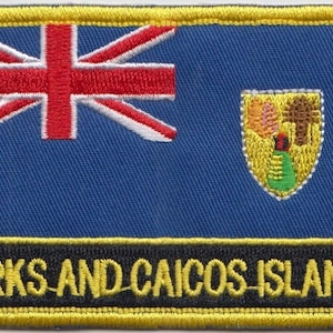 May include: An embroidered patch featuring the flag of the Turks and Caicos Islands. The flag is blue with a Union Jack in the top left corner and the coat of arms of the Turks and Caicos Islands in the bottom right corner. The text "TURKS AND CAICOS ISLANDS" is written in black letters on a yellow background.