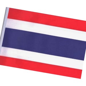 Puede incluir: Una pequeña bandera de Tailandia, con un diseño de cinco franjas horizontales. Las franjas superior e inferior son rojas, con una franja blanca encima y debajo de una franja azul más ancha en el centro. La bandera está montada en un palo blanco.