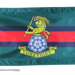 May include: A green flag with two black and red stripes. A yellow lion holding a staff with a red cross on top is in the centre of the flag. A white rose with a yellow scroll that says "YORKSHIRE" is below the lion.