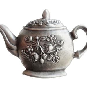 May include: A silver teapot with a floral design. The teapot has a lid and a spout. The teapot is made of metal and has a shiny finish.