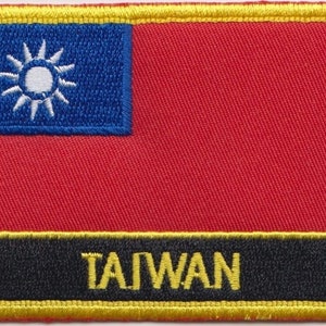 May include: An embroidered patch featuring the flag of Taiwan, with a red background, a blue canton with a white sun, and the word "TAIWAN" in yellow lettering on a black background.