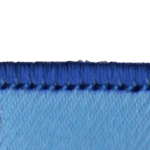 May include: Close-up of a light blue fabric with a dark blue stitched edge.