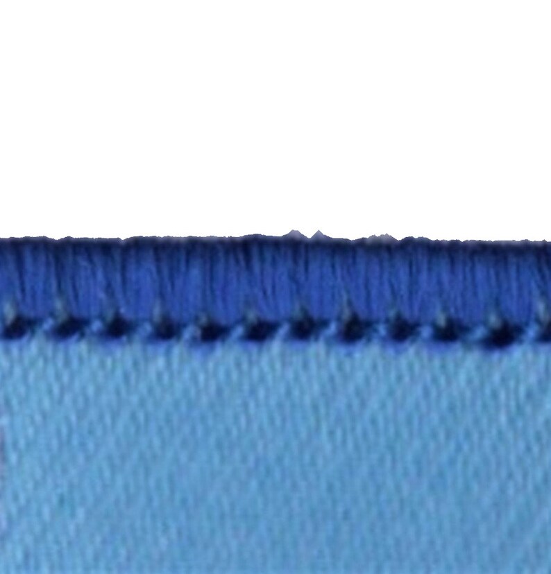 May include: Close-up of a light blue fabric with a dark blue stitched edge.