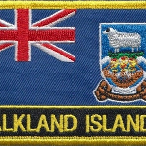 May include: A blue and white embroidered patch with the text "FALKLAND ISLANDS" and a crest featuring a white sheep and a ship.
