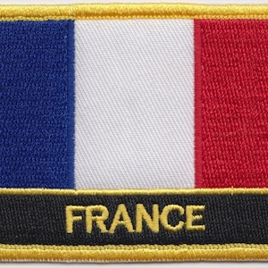 Könnte beinhalten: Ein gestickter Aufnäher in Blau, Weiß und Rot mit goldener Umrandung und dem Wort "FRANCE" in goldenen Buchstaben auf schwarzem Hintergrund.