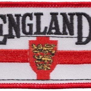 Op de afbeelding: Witte geborduurde patch met een rood kruis en drie gouden leeuwen in het midden. Het woord "ENGLAND" is in zwart boven het kruis geborduurd.