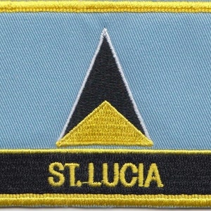 Pode incluir: Um remendo bordado em amarelo, preto e azul claro com um triângulo preto que contém um triângulo amarelo e o texto "ST. LUCIA" em amarelo.