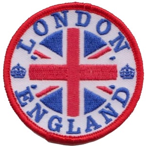 May include: A white embroidered patch with a red and blue Union Jack design. The words "LONDON" and "ENGLAND" are written in a circle around the flag. There are two small crowns on either side of the flag.