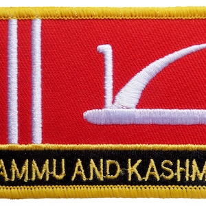 May include: A red embroidered patch featuring a white crescent moon and three white vertical stripes. The text "JAMMU AND KASHMIR" is embroidered in yellow on a black background at the bottom of the patch.