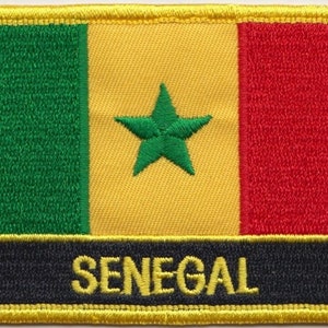 Könnte beinhalten: Ein gestickter Aufnäher mit der Flagge des Senegals. Die Flagge ist grün, gelb und rot mit einem grünen fünfzackigen Stern in der Mitte des gelben Streifens. Die Worte "SENEGAL" sind in Gelb auf schwarzem Hintergrund unter der Flagge gedruckt.
