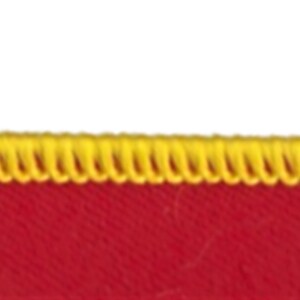 May include: Red fabric with a yellow zig-zag stitch along the top edge.