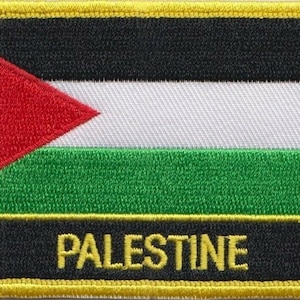 May include: An embroidered patch with a black, white, green and red design. The patch has a yellow border and features a triangle with a red background. The word "PALESTINE" is written in yellow letters.