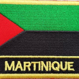 Peut inclure: Un écusson brodé jaune avec un motif de drapeau vert, noir et rouge. Le texte "MARTINIQUE" est brodé en jaune en bas de l'écusson.