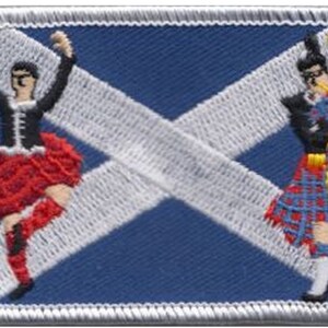 May include: A blue and white Scottish flag patch with a white cross. The patch features a woman in a kilt and a man playing bagpipes.