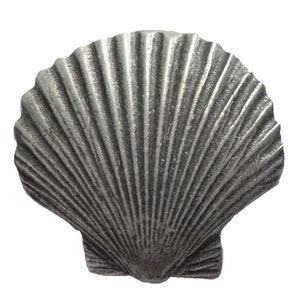 May include: A silver-coloured seashell with a detailed, ribbed texture. The shell is a decorative accent for a home or craft project.