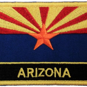 以下が含まれることがあります： アリゾナ州の州旗が刺繍されたパッチ。旗は赤と黄色の太陽の光線模様で、青い背景に赤い五芒星が描かれている。"ARIZONA"という文字が黒地に黄色で刺繍されている。