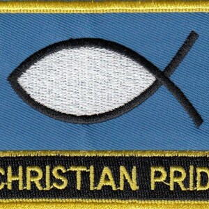 Pode incluir: Um remendo azul com um símbolo de peixe branco e o texto "CHRISTIAN PRIDE" em letras amarelas sobre fundo preto.