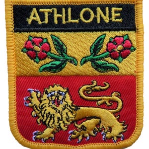 May include: Embroidered patch with the word "ATHLONE" in black on a yellow and red background. The patch features a lion, roses, and green leaves. The patch has a yellow border.