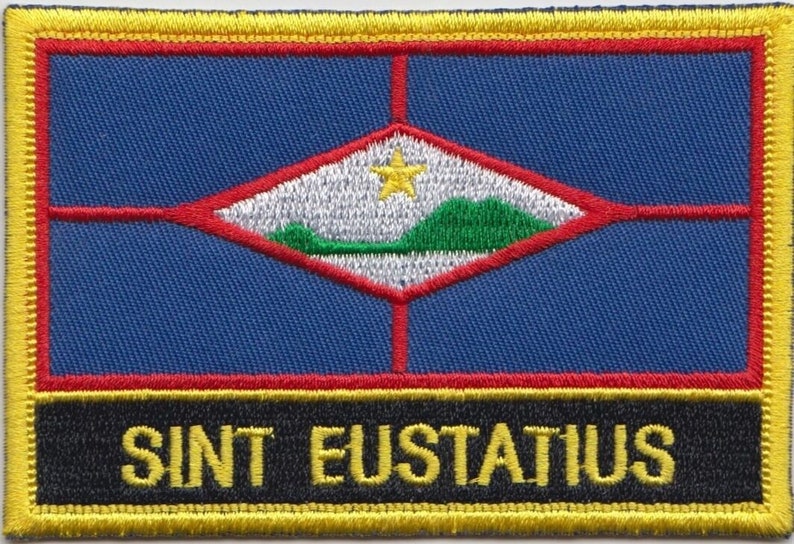 Peut inclure: Un &eacute;cusson brod&eacute; bleu, rouge et jaune avec un losange blanc contenant une colline verte, une &eacute;toile jaune et le texte "SINT EUSTATIUS".